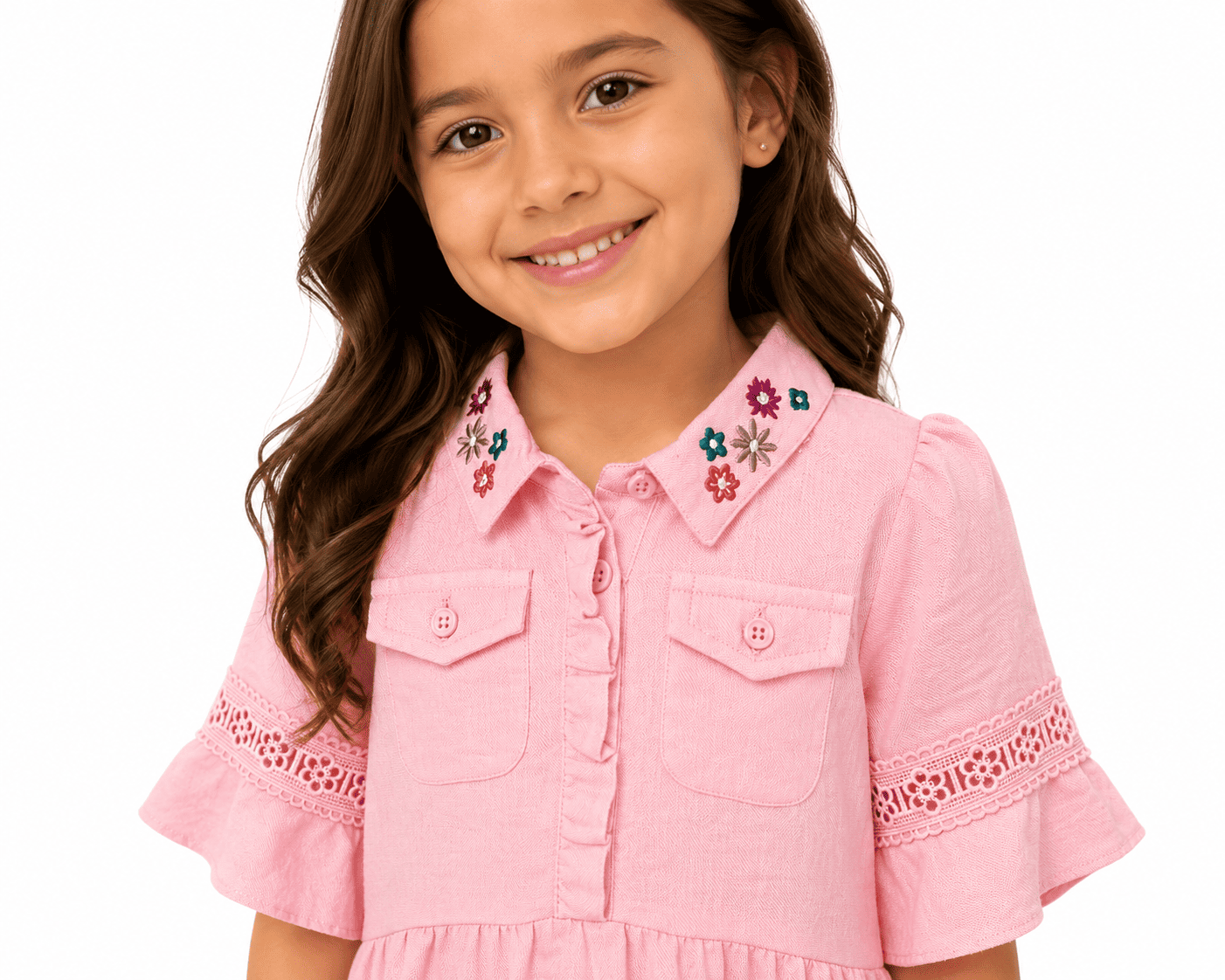Young girl wearing a pink dress with floral embroidery on a white background